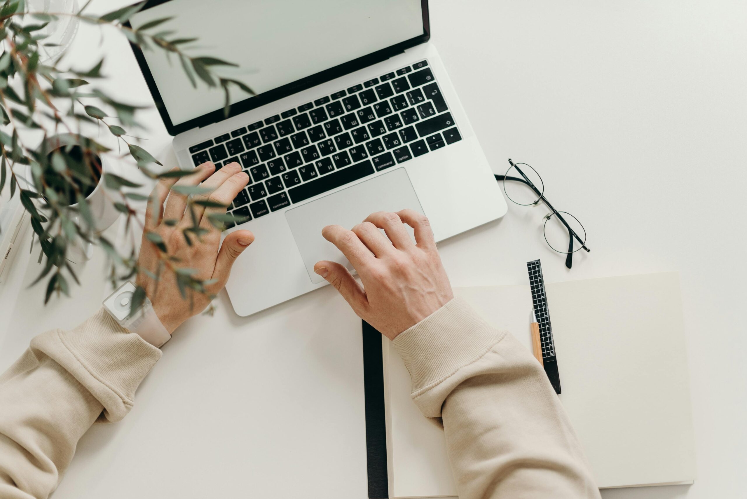 Woman writing on a laptop with a coffee